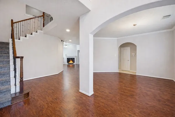 a view of a livingroom with wooden floor and staircase