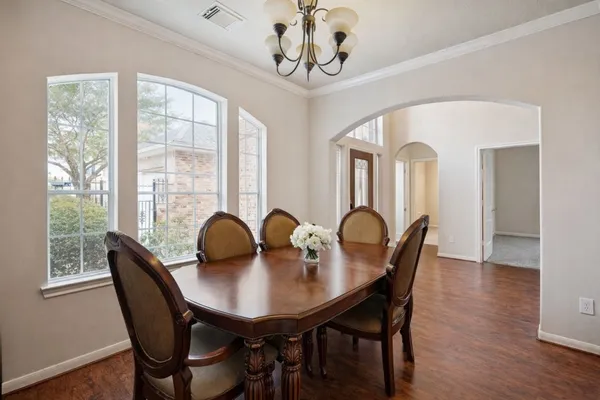 a dining room with furniture a chandelier and wooden floor