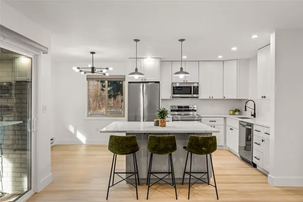 a kitchen with kitchen island wooden cabinets and stainless steel appliances
