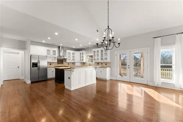 an empty room with wooden floor and a ceiling fan