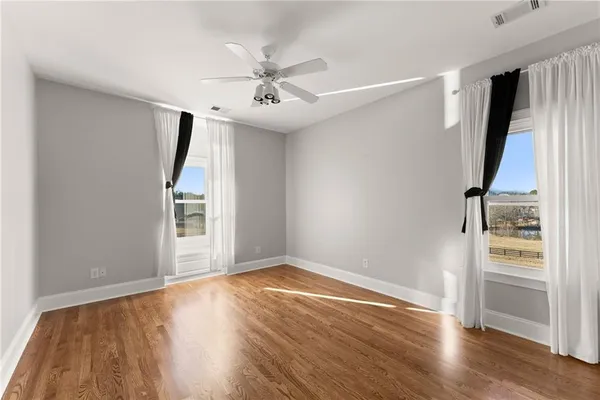 a view of a room with wooden floor and a ceiling fan