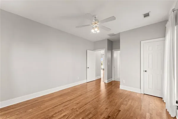 an empty room with a window and a ceiling fan