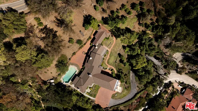 an aerial view of house with yard and mountain view in back