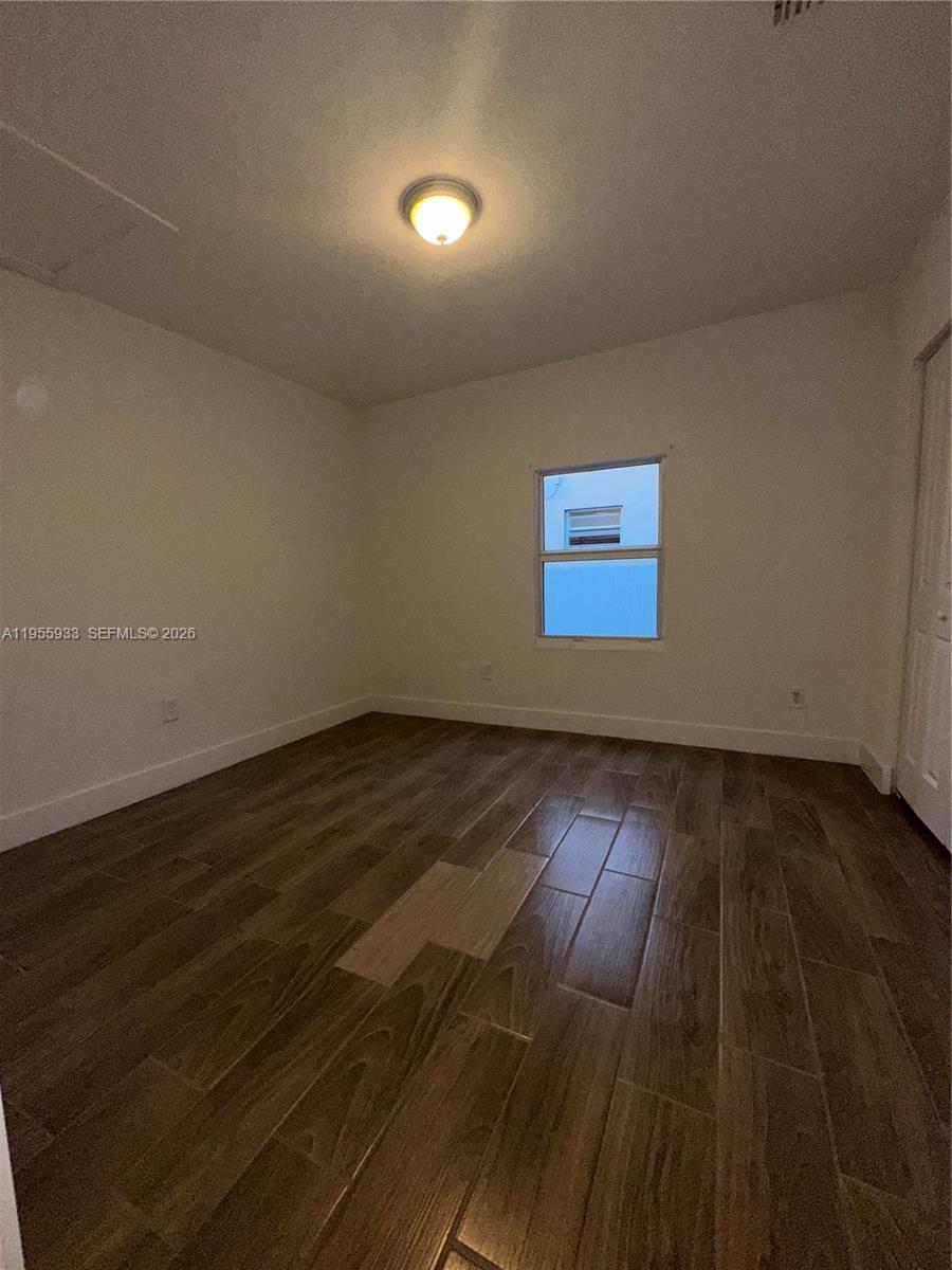 3123 Northwest 22nd Court, Unit A Miami, FL 33142 - Photo 14 of 18 a view of wooden floor and windows in a room