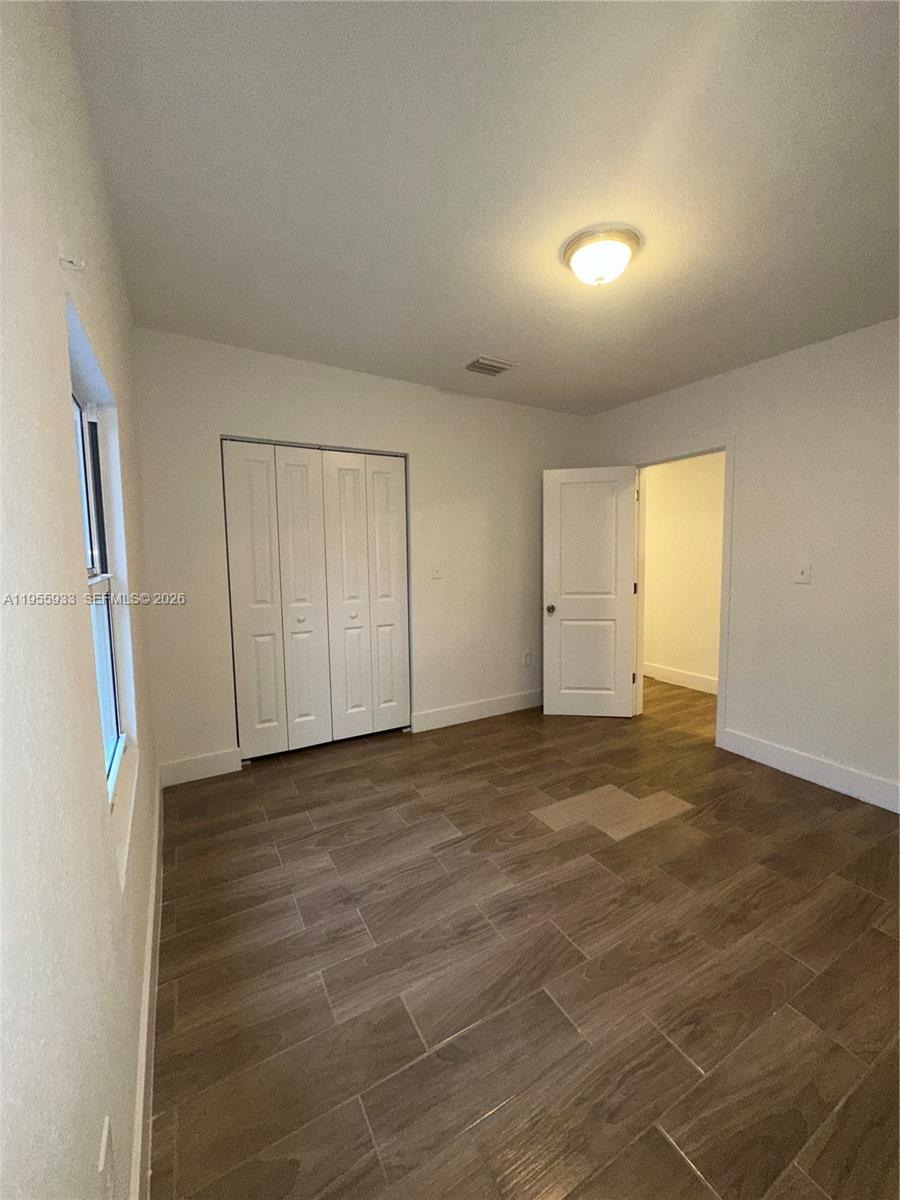3123 Northwest 22nd Court, Unit A Miami, FL 33142 - Photo 15 of 18 a view of an empty room and wooden floor