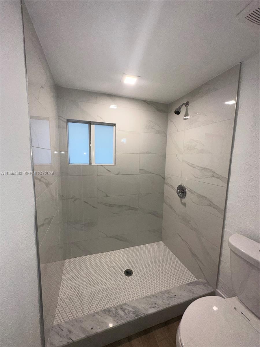3123 Northwest 22nd Court, Unit A Miami, FL 33142 - Photo 17 of 18 a bathroom with a tub and a shower