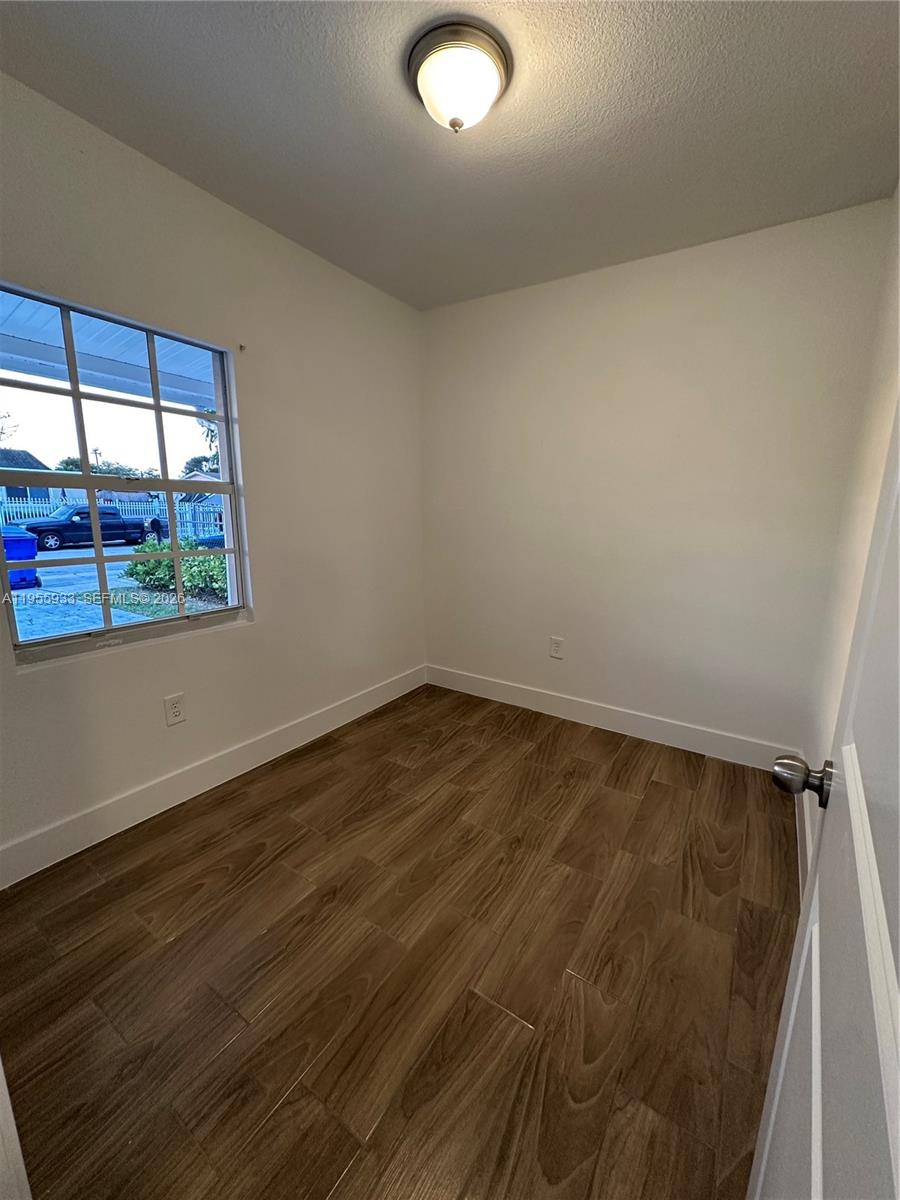 3123 Northwest 22nd Court, Unit A Miami, FL 33142 - Photo 6 of 18 a view of a room with wooden floor and windows