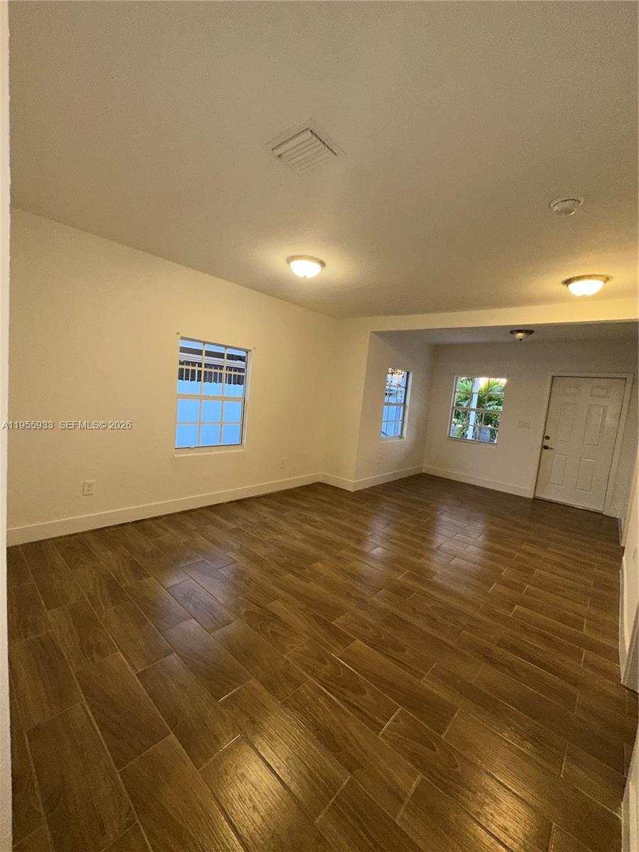 3123 Northwest 22nd Court, Unit A Miami, FL 33142 - Photo 9 of 18 a view of empty room with window and wooden floor