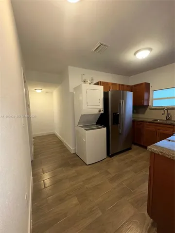 a view of a refrigerator in kitchen and a sink