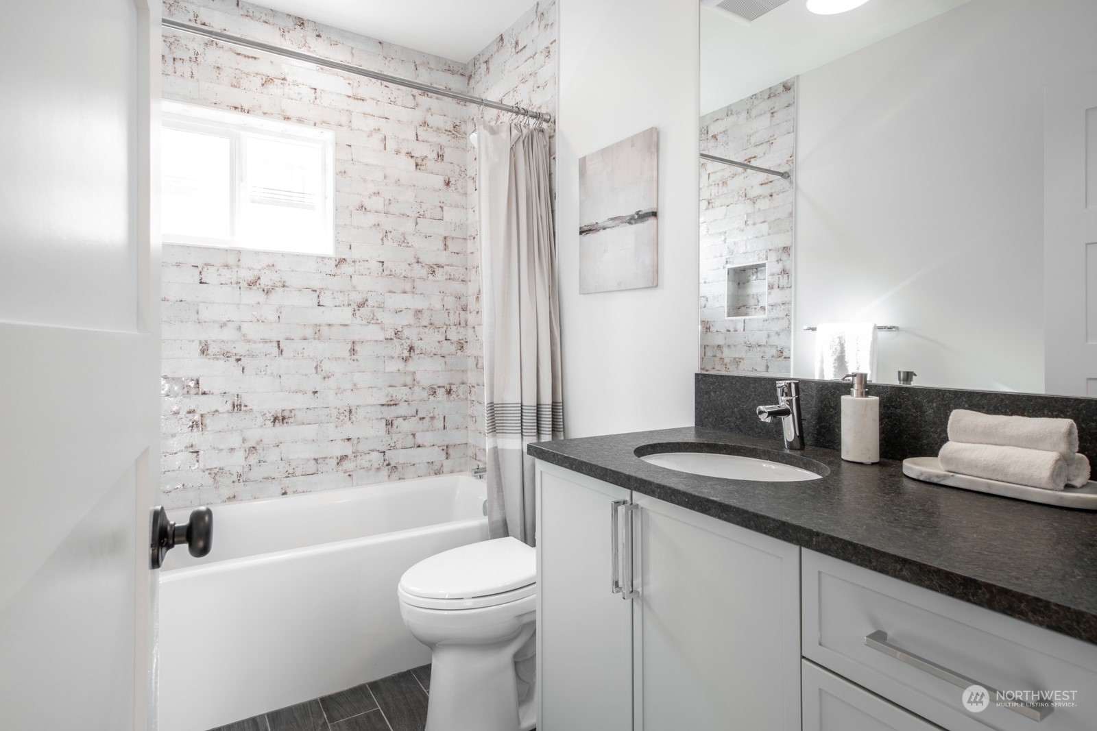 3649 Francis Avenue North, Unit A Seattle, WA 98103 - Photo 22 of 35 a bathroom with a granite countertop sink a toilet a mirror and shower