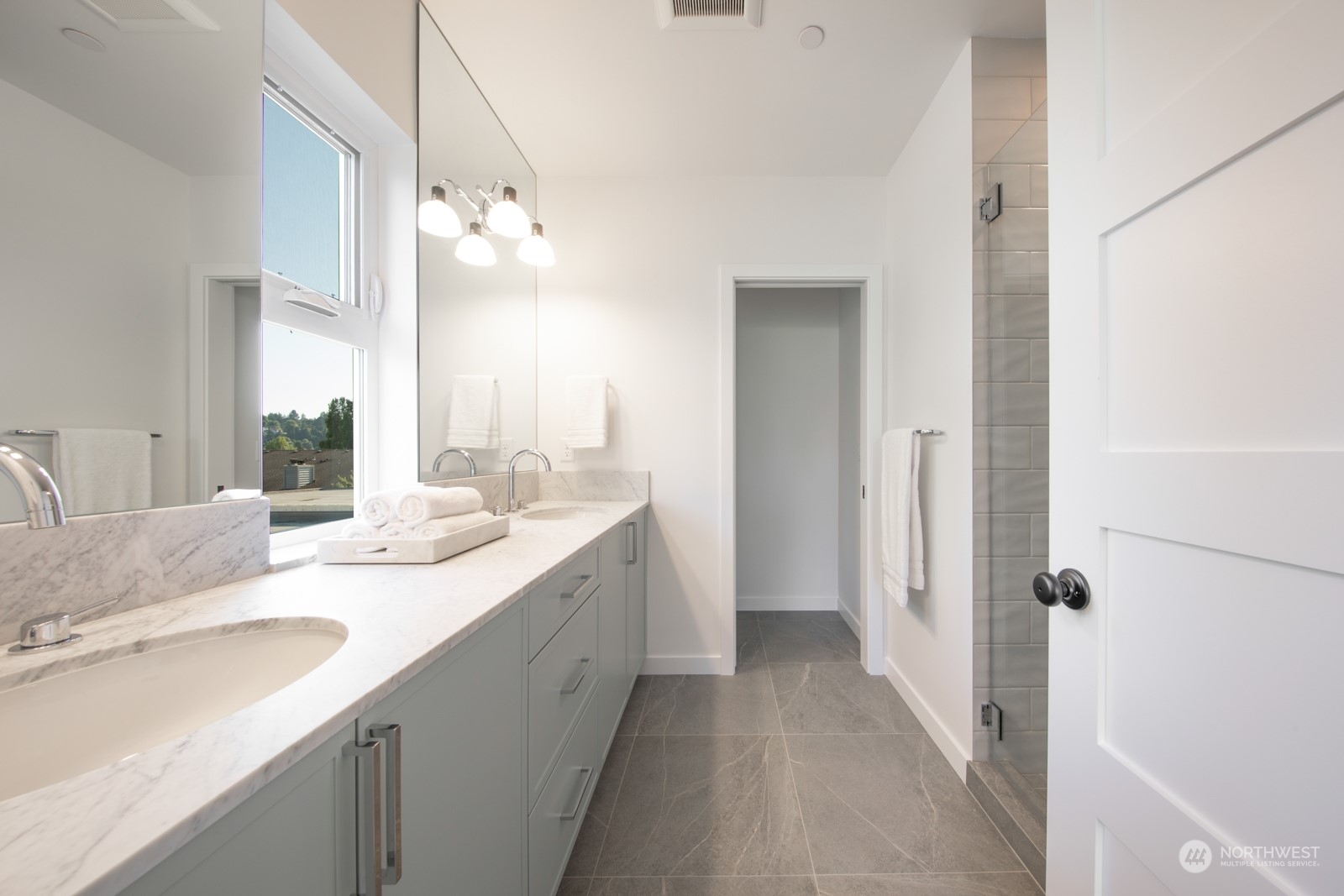 3649 Francis Avenue North, Unit A Seattle, WA 98103 - Photo 25 of 35 a bathroom with a double vanity sink a mirror and a shower