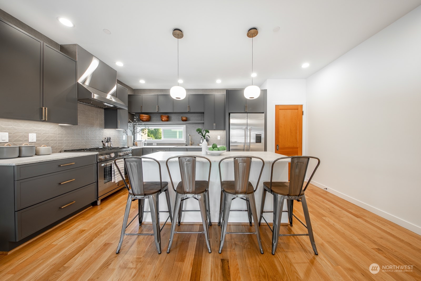 3649 Francis Avenue North, Unit A Seattle, WA 98103 - Photo 7 of 35 a kitchen with stainless steel appliances granite countertop a kitchen island hardwood floor and a sink