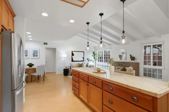 a large kitchen with kitchen island a large counter top space a sink stainless steel appliances and cabinets