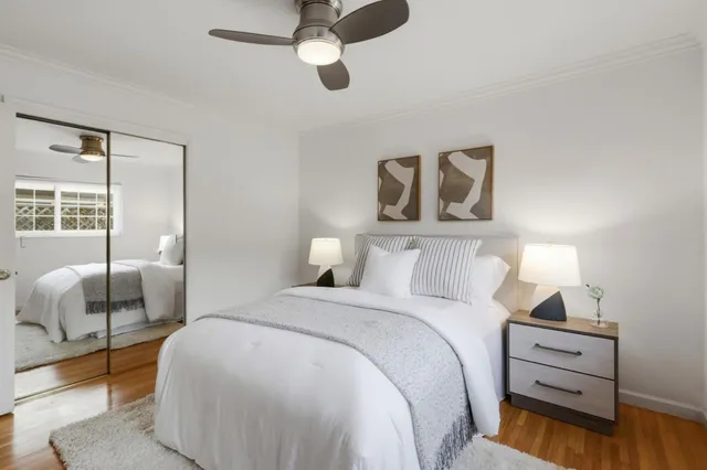 a bedroom with a bed and wooden floor