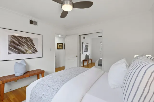 a bedroom with bed and a painting on the wall