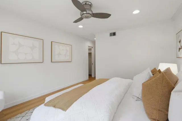 a bedroom with a bed and a painting on the wall