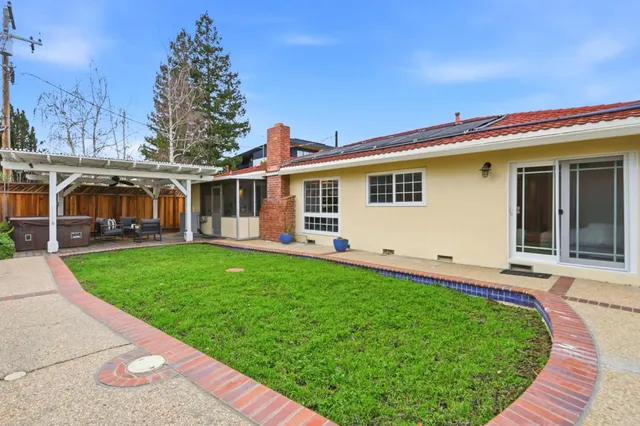 a view of a house with backyard and sitting area