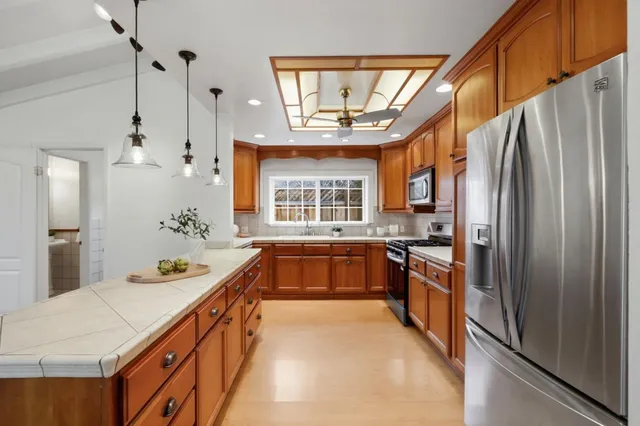 a kitchen with stainless steel appliances a sink stove and refrigerator