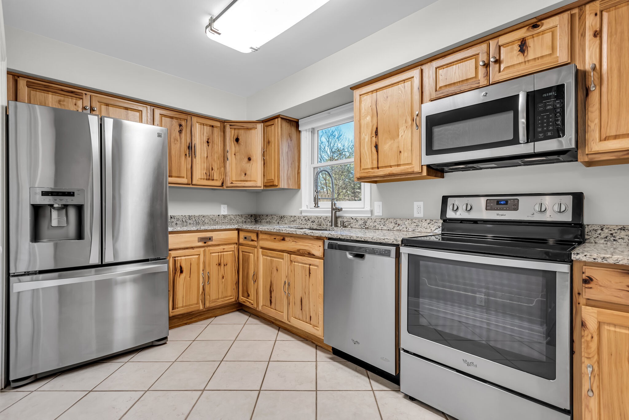 a kitchen with stainless steel appliances granite countertop a refrigerator stove top oven and microwave