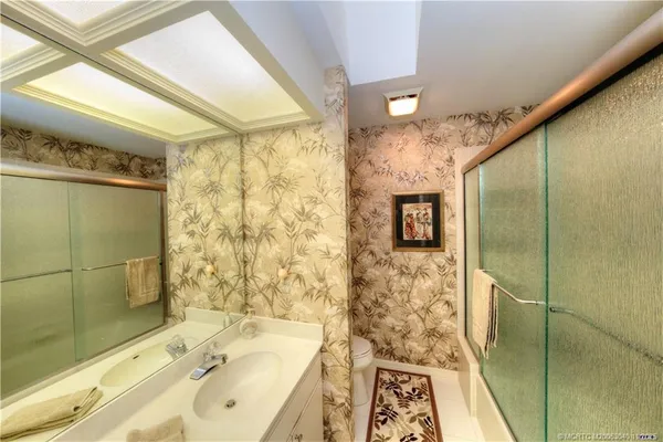 a spacious bathroom with a granite countertop sink and a mirror