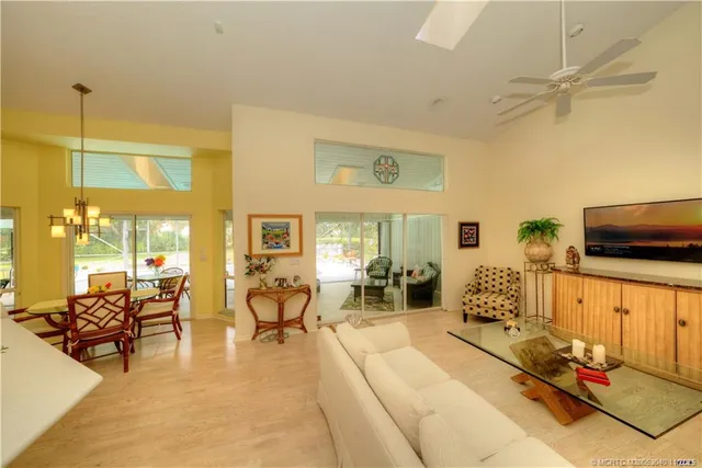 a view of a swimming pool with a lawn chairs under palm trees