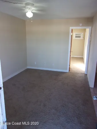 en empty room with window and hardwood floor