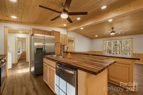 a open kitchen with stainless steel appliances granite countertop a sink and a refrigerator
