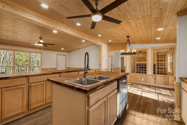 a kitchen that has a sink and a stove with wooden floor