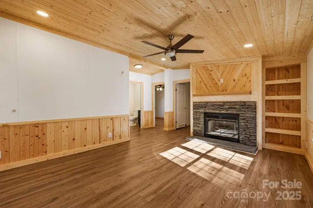 a view of an empty room with a fireplace and a window