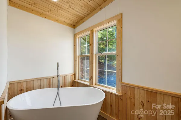a white bath tub sitting in a bathroom next to a window