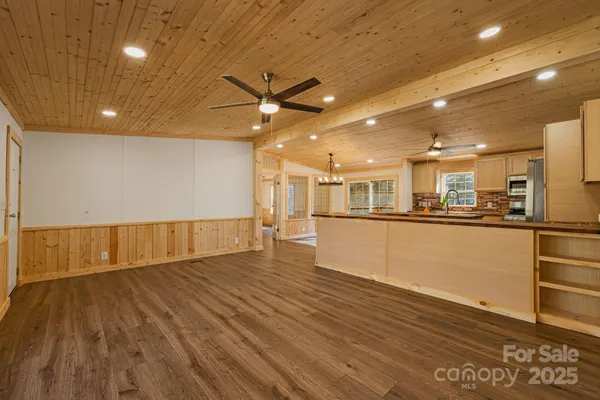 a view of kitchen and a hallway with wooden floor