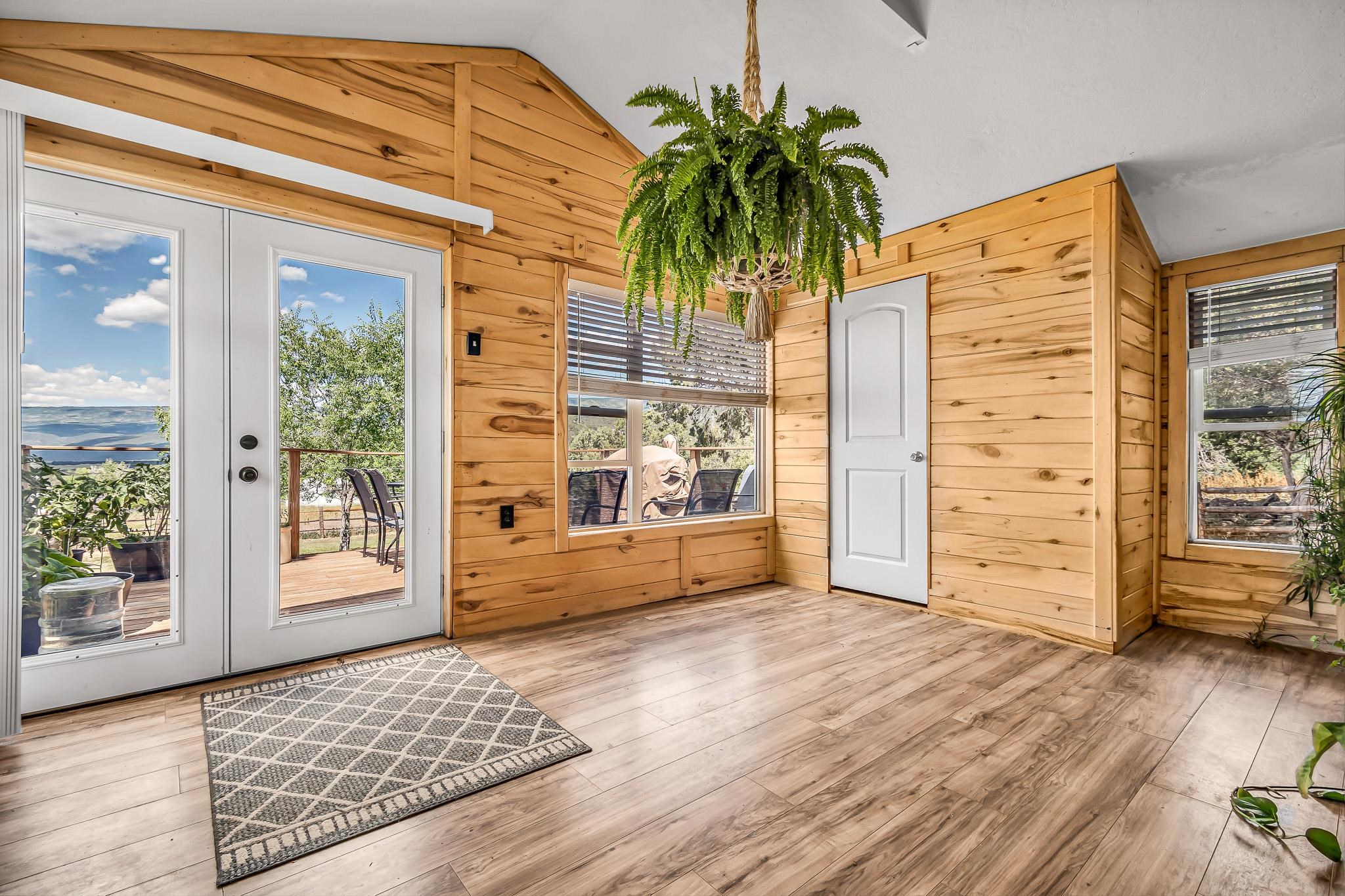 24413 Ute Trail Road Cedaredge, CO 81413 - Photo 11 of 40 a view of a hallway with wooden floor and a living room
