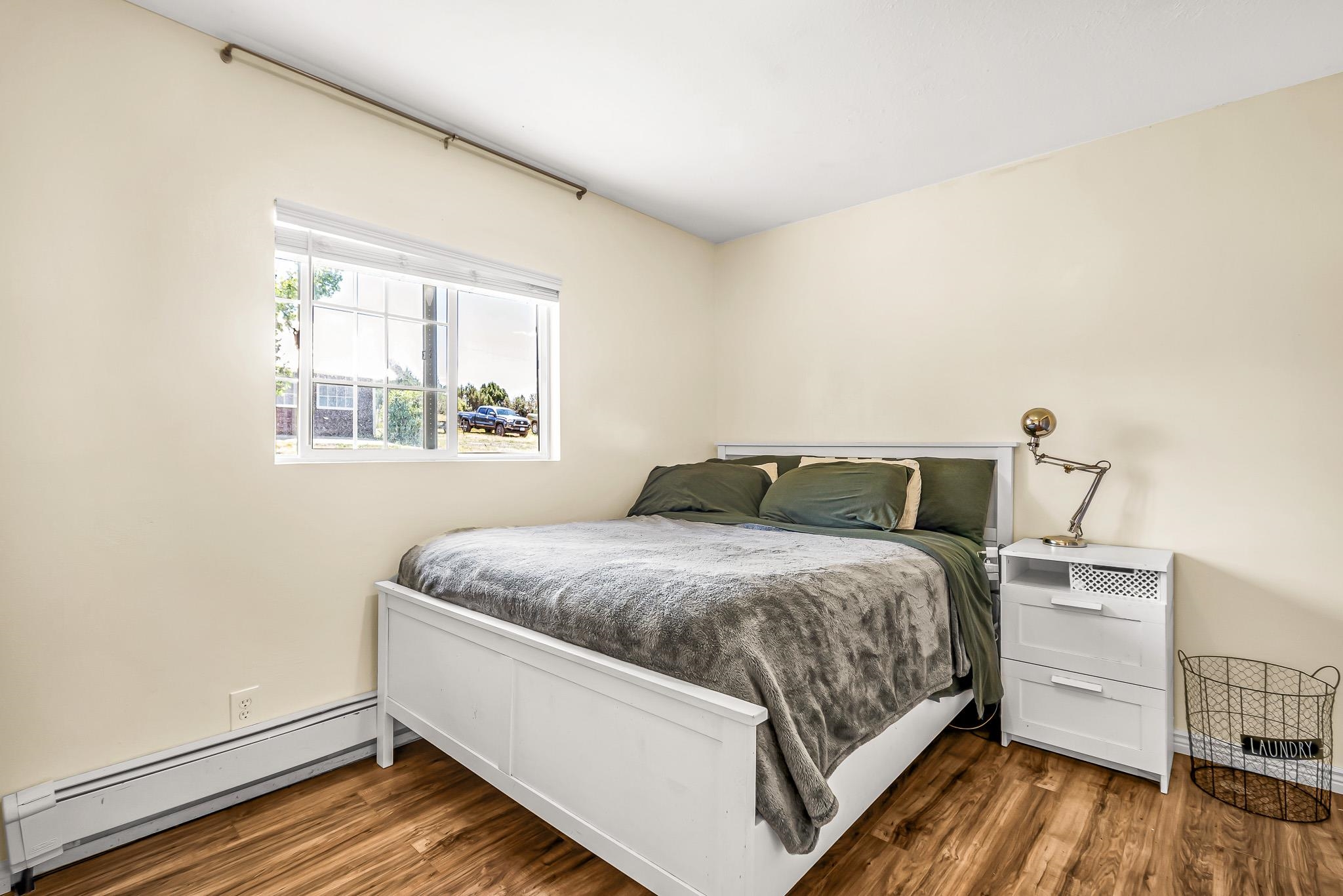 24413 Ute Trail Road Cedaredge, CO 81413 - Photo 13 of 40 a bed sitting in a bedroom next to a window with wooden floor