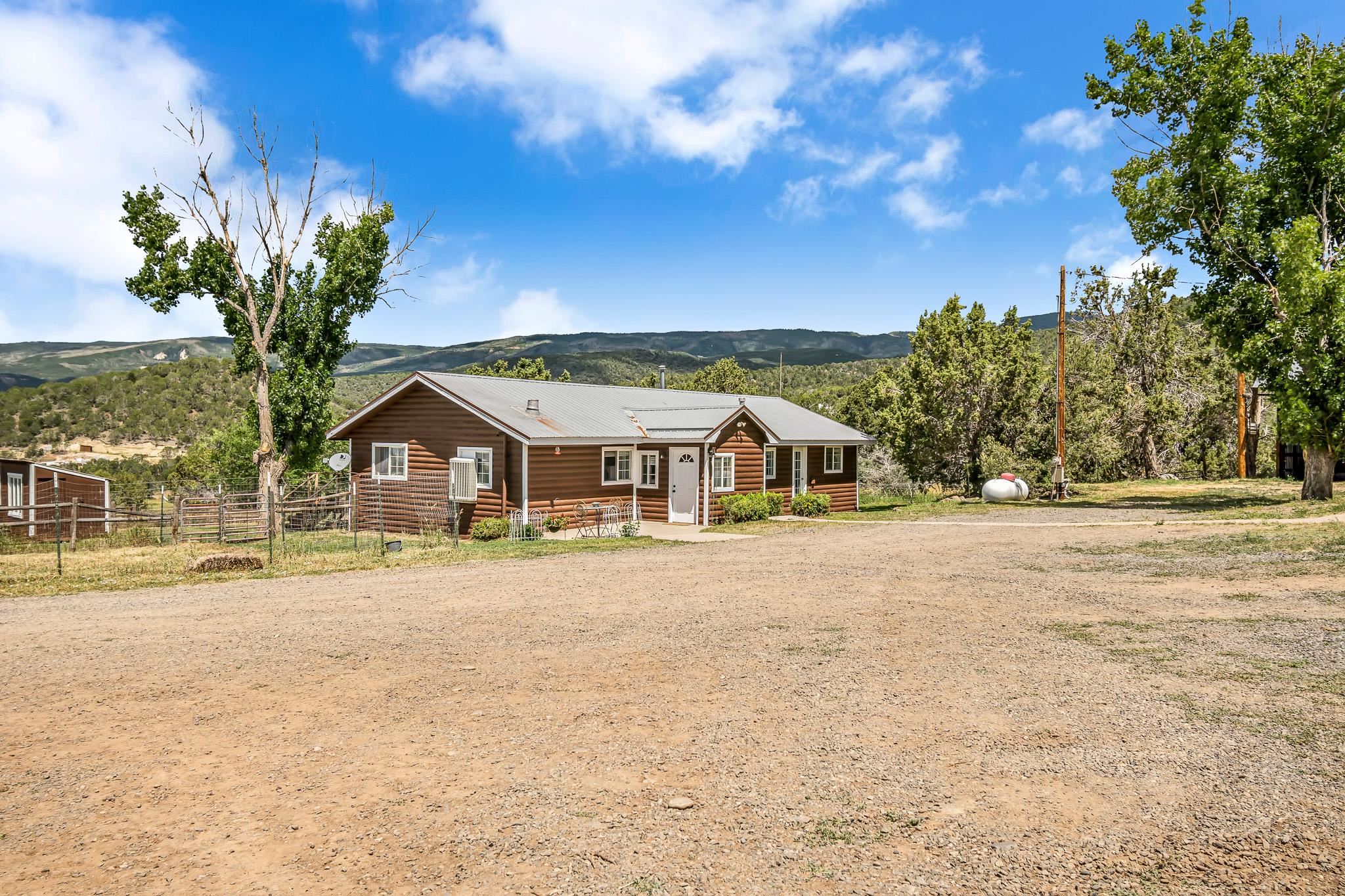 24413 Ute Trail Road Cedaredge, CO 81413 - Photo 40 of 40 a front view of a house with a yard and mountain view