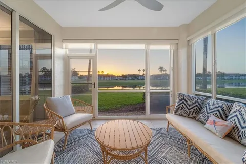 a living room with furniture and a floor to ceiling window