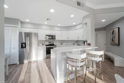a kitchen with kitchen island stainless steel appliances a refrigerator and a stove top oven