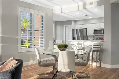 a view of a dining room with furniture a chandelier and wooden floor