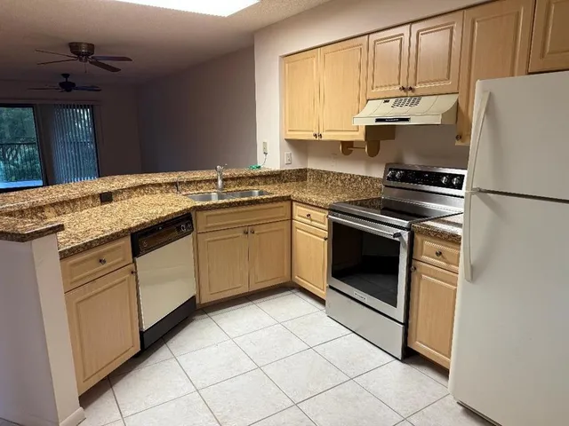 a kitchen with granite countertop cabinets stainless steel appliances and a sink