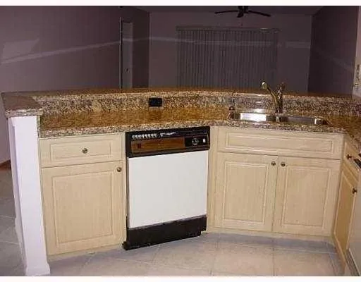 a kitchen with granite countertop cabinets and white appliances