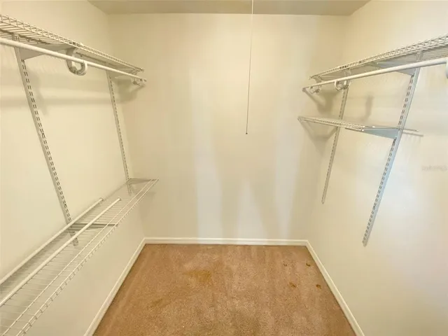 a view of walk in closet with wooden floor