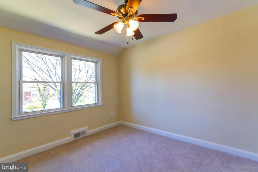 1027 Witherspoon Road Baltimore, MD 21212 - Photo 12 of 21 an empty room with a window and a fan