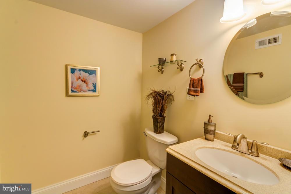 1027 Witherspoon Road Baltimore, MD 21212 - Photo 17 of 21 a bathroom with a sink mirror vanity and toilet