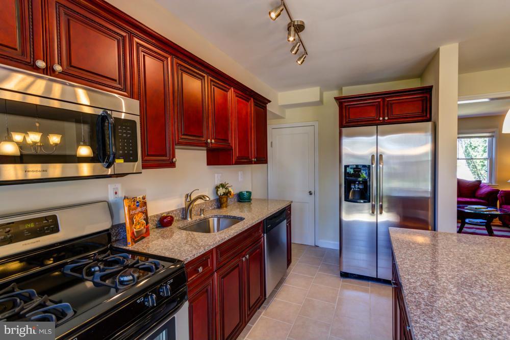 1027 Witherspoon Road Baltimore, MD 21212 - Photo 3 of 21 a kitchen with stainless steel appliances granite countertop a stove and a microwave