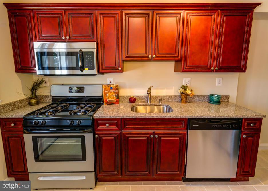 1027 Witherspoon Road Baltimore, MD 21212 - Photo 4 of 21 a kitchen with stainless steel appliances granite countertop a stove and a microwave