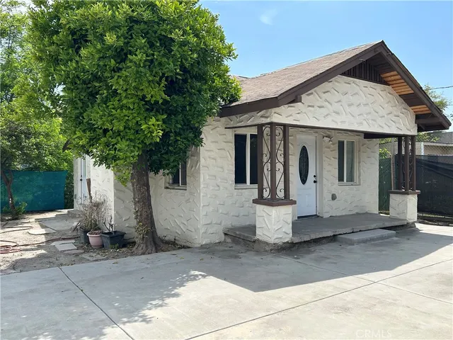 a front view of a house with white fence
