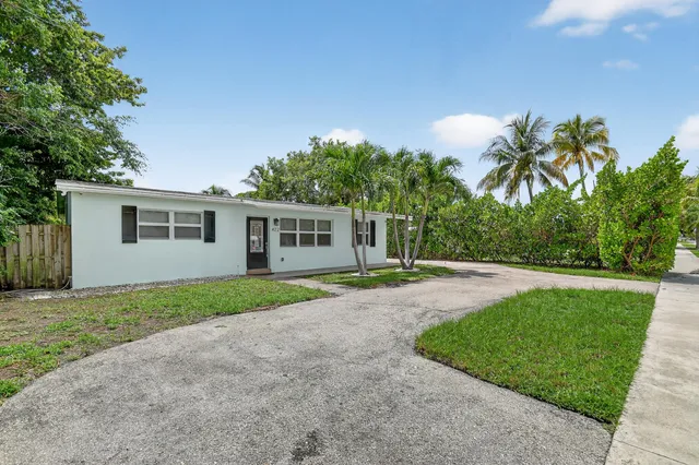 a front view of a house with a yard and trees