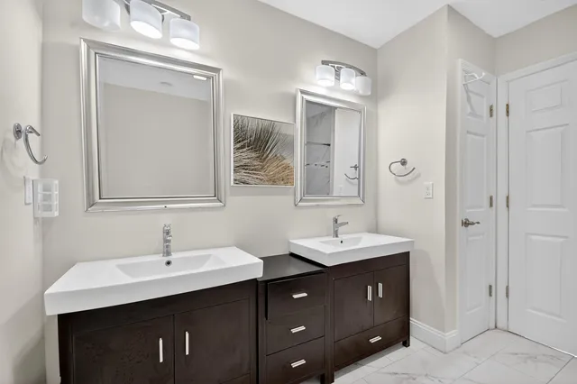 a bathroom with a double vanity sink and mirror