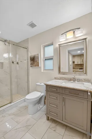 a bathroom with a granite countertop toilet a sink and a mirror