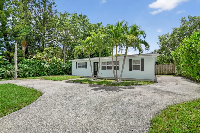 a view of a house with backyard and trees