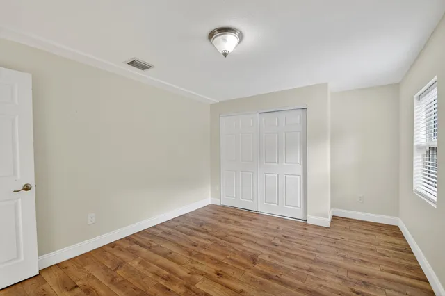 a view of empty room with wooden floor